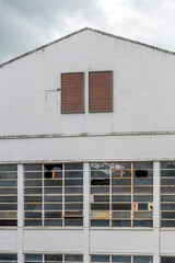 Facade of Abandoned Industrial Building with Broken Windows