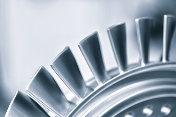 A close up of a turbine blade with a silver color. Concept of precision and engineering, as the blade is a crucial component of a turbine. The focus on the blade highlights its intricate design