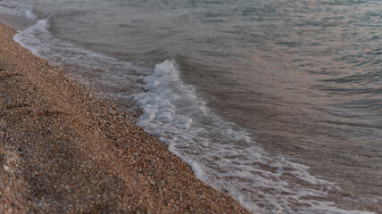 Foam of the surf covering the sandy shore