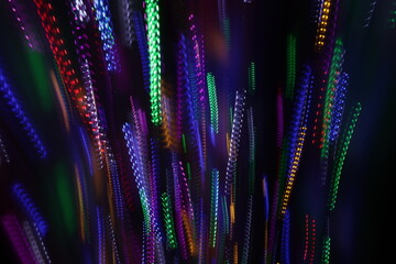 Una toma de cerca de varias luces de colores en movimiento en la oscuridad. Movimiento de cámara  © Elika R