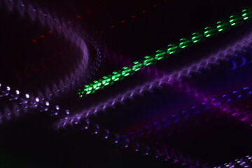 Una toma de cerca de varias luces de colores en movimiento en la oscuridad. Movimiento de cámara 