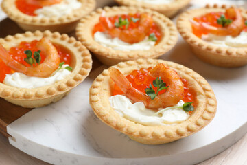 Delicious canapes with shrimps, red caviar and cream cheese on light table, closeup