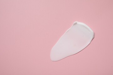 Face cream on pink background, top view. Space for text
