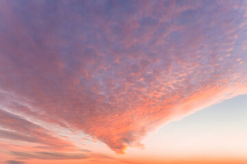 A beautiful sky tinted by the sun leaving vibrant shades of gold, pink, blue and multicolored. Clouds in the twilight evening and morning sky. Cloudy sky background in the evening and during the day.