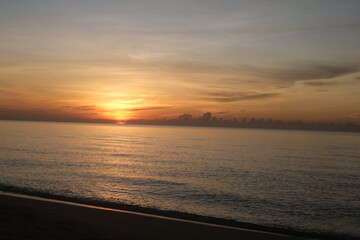 The sun rises at the sea in the morning.