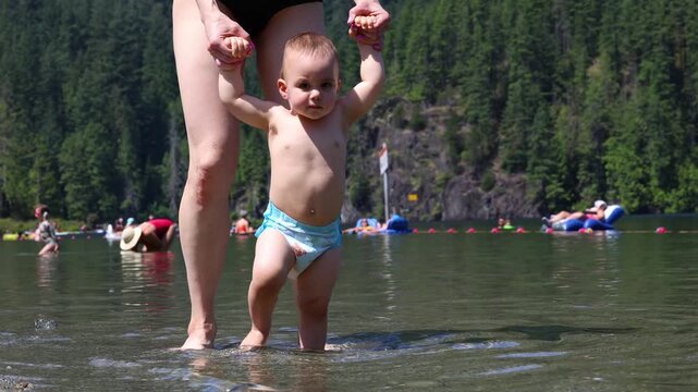 Toddler Learning to Walk in Water. Buntzen Lake, Anmore, British Columbia, Canada.