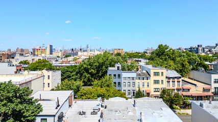 Naklejka premium A stunning aerial view of Brooklyn, NY, showcasing vibrant city streets and diverse architecture with the iconic New York City skyline in the background. 