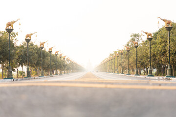 Highway road with sky clouds at sunset, The road leading to Phikun Thong Temple at Sing Buri, Thailand.