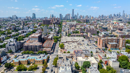 Fototapeta premium A stunning aerial view of Brooklyn, NY, showcasing vibrant city streets and diverse architecture with the iconic New York City skyline in the background. 