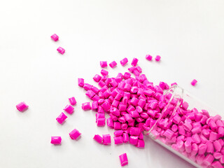 Neon pink masterbatch granules on white background. Color pigment carrier polymer in plastic...
