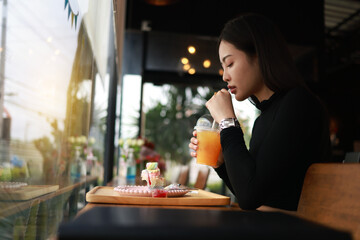 Attractive young woman having a Relax time with a beverage at a coffee shop sitting on the chair