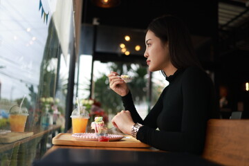 Attractive young woman having a Relax time with a beverage at a coffee shop sitting on the chair