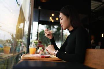 Attractive young woman having a Relax time with a beverage at a coffee shop sitting on the chair
