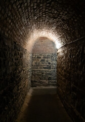 Fototapeta premium The corner of the narrow stone tunnel passing under fortress walls in the Vysehrad district of Prague in Czech Republic