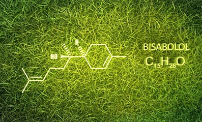Bisabolol or levomenol molecule. It is natural monocyclic sesquiterpene alcohol, used in various fragrances. Skeletal chemical formula. Green grass background. 3D render