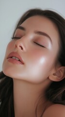Fototapeta premium Portrait of young woman with glowing skin against a light background