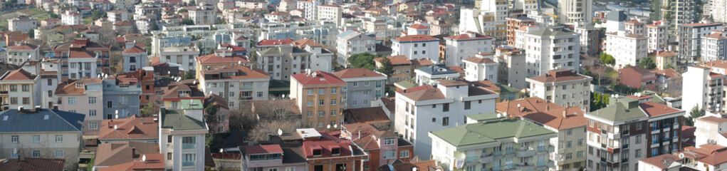Fototapeta premium Aerial View of a Diverse Urban Landscape Featuring RedTiled Roofs and Tall HighRise Buildings