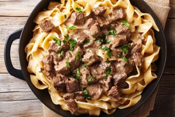 Delicious beef stroganoff with noodles in a black skillet.
