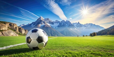 soccer ball on green field with mountains in background