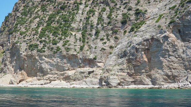 RT Dubovica Rocks near Buljarica and Svetac Rock, Montenegro. Stones, inaccessible rocks. Flysch marine lithological layers. Adriatic Mediterranean sea blue water. Nature park Katici. District Budva.