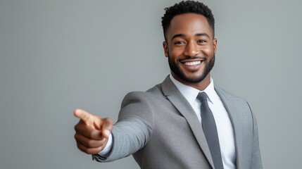 A cheerful man in a suit points toward the viewer with a bright smile