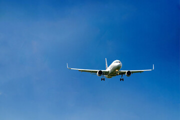 White passenger airplane flying in the sky amazing clouds in the background