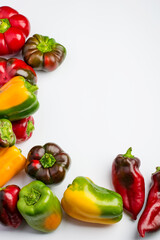 Multi-colored bell peppers on a white background, top view, copy space..