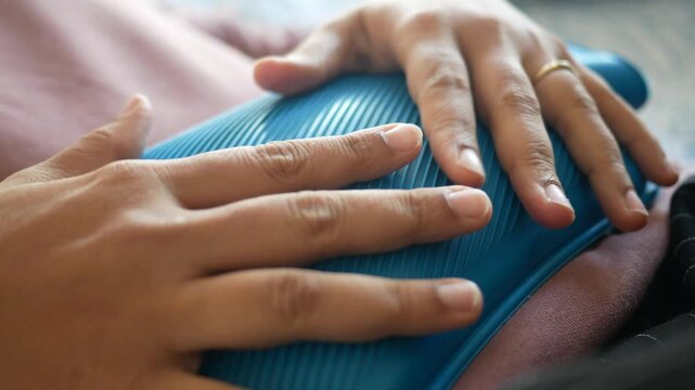 woman using hot water bag for period pain