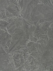 Chrystal clear frosty textured natural ice block in cold shades of grey tones, isolated on black background.