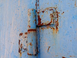 Old rusty curtain of blue color on metal door. Industrial backgrounds with old metal surfaces with...