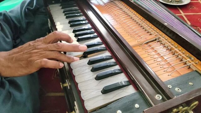 A Man Playing Harmonium. Closeup shot of hands of a Man playing Harmonium. Traditional world. Folk instrument. Pakistani man playing harmonium in the house. Beautiful Slow motion 4K Footage.