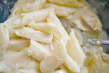 Creamy chicken pasta and spoon in a bowl. Closeup food. Italian dish style.