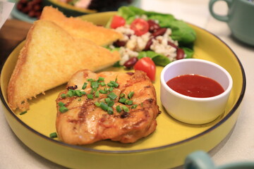 Grilled chicken breast served with crispy French fries, a fresh salad, and a side of tangy barbecue sauce is perfect for food lovers and culinary enthusiasts.