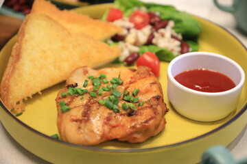 Grilled chicken breast served with crispy French fries, a fresh salad, and a side of tangy barbecue sauce is perfect for food lovers and culinary enthusiasts.