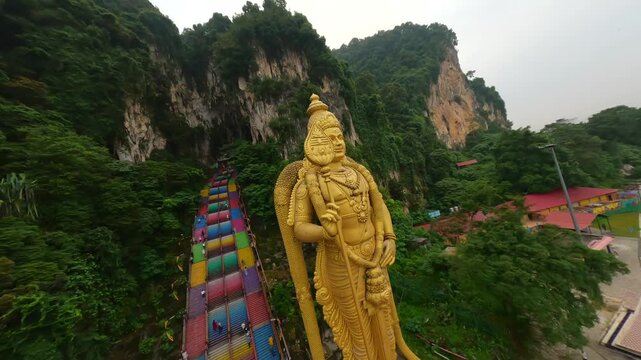 Cinematic FPV shot of Batu Caves and gold statue of Murugan in Kuala Lumpur, Malaysia