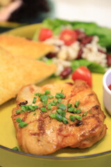 Grilled chicken breast served with crispy French fries, a fresh salad, and a side of tangy barbecue sauce is perfect for food lovers and culinary enthusiasts.