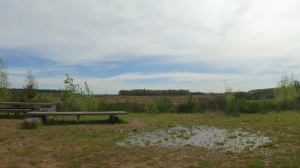 Resting place and viewpoint with picnic table and wooden bench at entrance to Mechelse Heide, plain in background, Hoge Kempen National Park, sunny day in As, Limburg, Belgium. Travelling shot