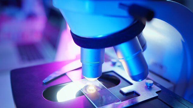 Laboratory Chemist Analyzing Samples With Advanced Technology in Neon Purple Lighting