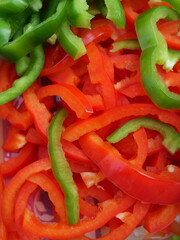 red and green bell peppers sliced into strips, perfect for salads, garnishing, or pizza topping. Fresh, high-quality, and healthy, available in supermarkets.