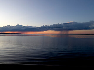 beautiful red sunset with an orange tint, relaxing on the lake shore with a kettle and tea ,with a hammock and a sap board for swimming and sports and health,recreation by the reservoir, summer
