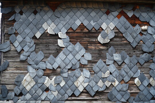 Facade of an abandoned house made of wood with panels of natural slate, most of the slates have fallen off. Background image of a lost place. Elende Bleicherode, Nordhausen, Thuringia, Germany.