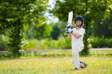 Kids playing cricket in summer park