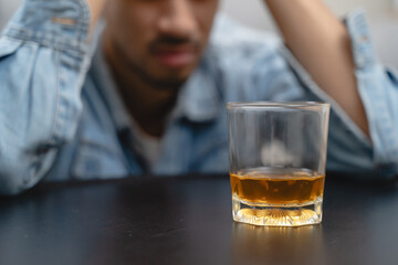 melancholy young Asian man drinks alcoholic whisky alone at home feeling dizzy after drunk