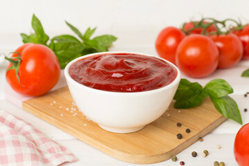 Delicious ketchup with spices and tomatoes on wooden table
