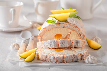 Tasty mango swiss roulade with fruits and powdered sugar.