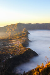 Morning misty fog at valley, half village and half mist valley