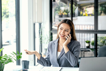 Successful businesswoman financier investors use smartphone to communicate remotely over the internet or video call to set challenging business goals and ready to achieve targets from work office