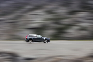 A moving car. High speed SUV with speed blur background. Side view