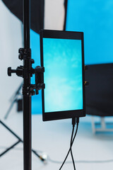 Illuminated display setup in a studio with vibrant blue backdrop during a creative session