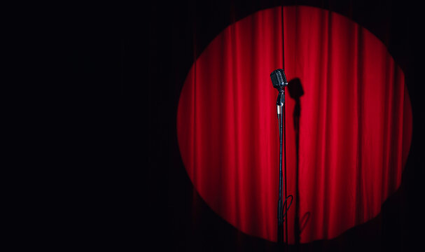 Concept stand up, comedian show banner. Old microphone on theater stage on red curtains background
